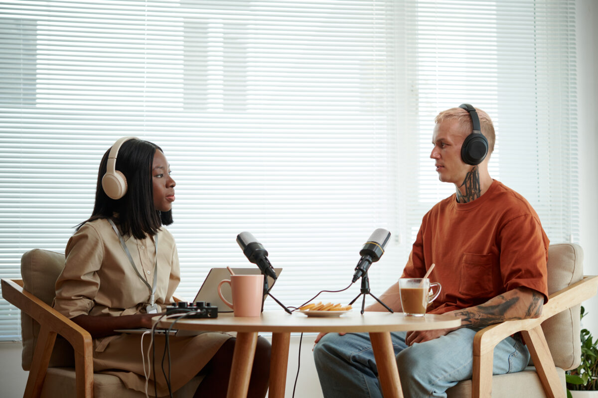 Deux personnes enregistrent un podcast assis à une table