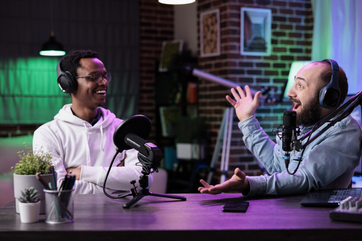 Deux hommes portant des écouteurs enregistrent un épisode de podcasts qu'ils vont héberger sur un flux RSS